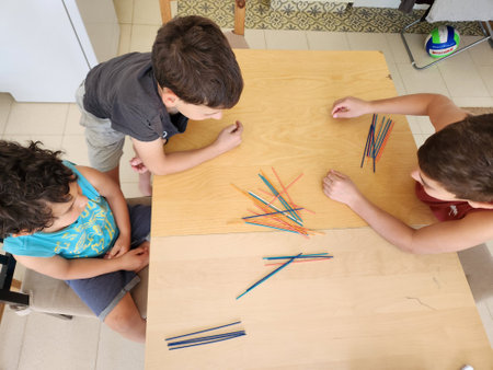 Top view of a group of children playing with pencils at the tableの写真素材