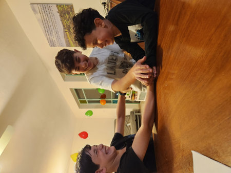 3 boys doing arm wrestling at homeの写真素材