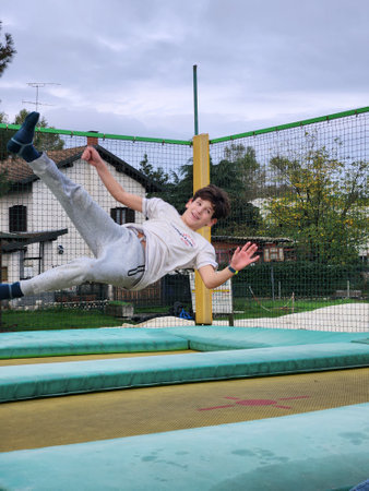 Young boy jumping on a trampoline on a sunny day.の写真素材