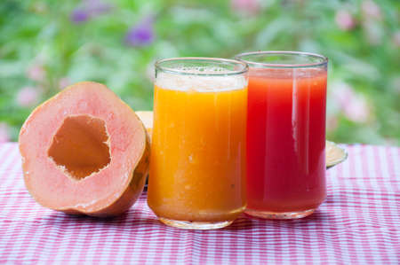 Smoothie papaya juice on table with garden flower backgroundの写真素材
