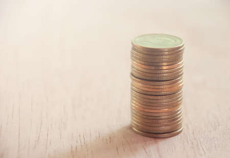 Row of coins on brown background, finance and banking conceptの写真素材