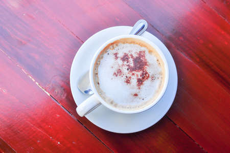 Hot coffee in white cup on wooden tableの写真素材