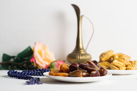 Sweets, dates, dried apricots on a plate. Flower. The concept of Ramadan, iftar.
