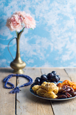 Sweets, dates, dried apricots on a plate. Flower. The concept of Ramadan, iftar.