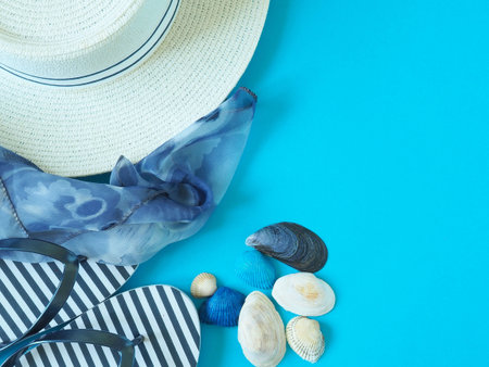 Concept of summer holidays with beach items on a blue background. The view from the top.