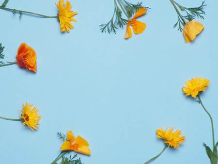 Floral pattern of orange flowers on blue background. Flat lay. Copy space.