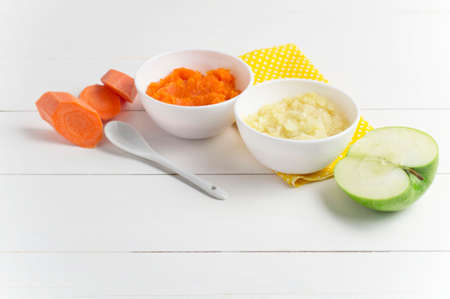 Baby food in bowls on a wooden white background.の写真素材