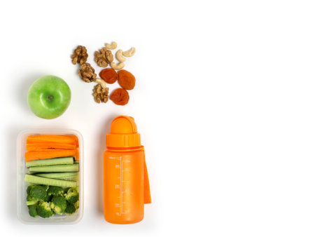 School lunch box with vegetables on a white background, top view. Flat lay.