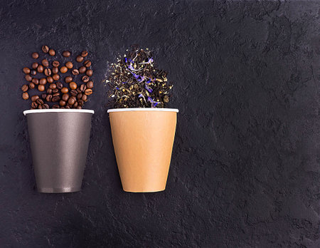 Coffee beans, tea in a paper Cup on a black concrete background. Concept of coffee, tea for cafes. Creative.の写真素材