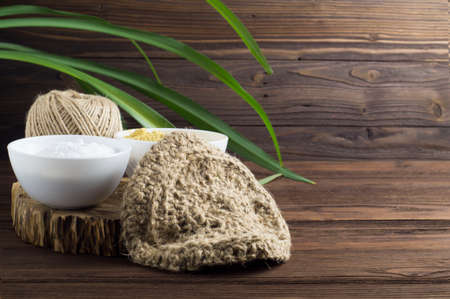 Natural jute sponge for washing dishes and natural detergents made of soda and mustard on a dark wooden background. The concept of zero waste.の写真素材