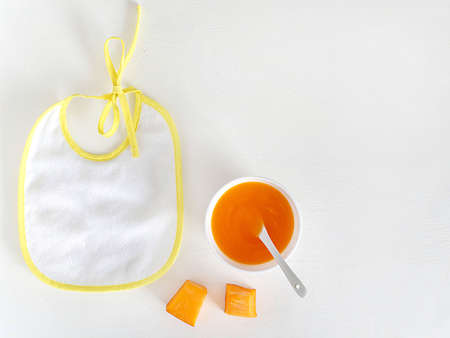 Bib, baby puree, spoon, Apple. The view from the top, flat lay.The concept of healthy nutrition for children. Copy space.の写真素材
