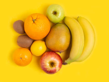 Fruit on a yellow background. The concept of healthy eating, vegan. vegetarianism. Copy location, top view. Flat lay.の写真素材