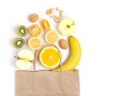 Paper bag with fruit on a white background. Copy location, top view. Flat lay.の写真素材