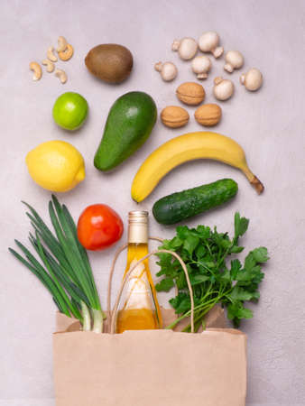 Paper bag with various healthy food on a gray concrete background, flat layの写真素材