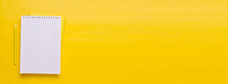 White Notepad and yellow pen on a yellow background. Minimalism.