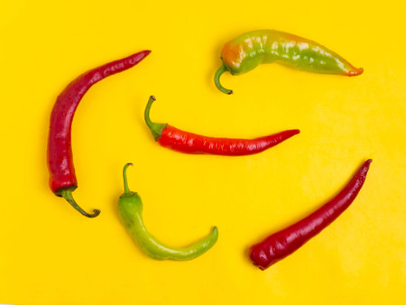 Sweet and hot pepper on a yellow background. A large number of peppers in the pile.