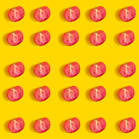Pattern of half a tomato on a yellow background.の写真素材