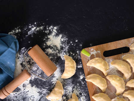 Preparing, cooking, making homemade ravioli, pelmeni or dumplings with meat on wooden table top view. Top view.の写真素材