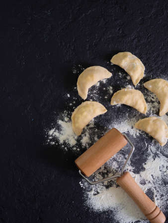 Preparing, cooking, making homemade ravioli, pelmeni or dumplings with meat on wooden table top view. Top view.の写真素材