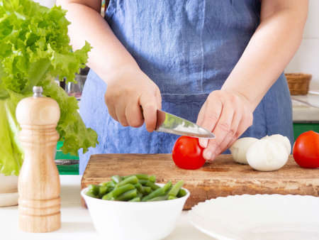 A woman prepares a vegetable salad in the kitchen. Healthy Food. The Concept Of A Diet. Healthy Lifestyle. I Cook At Home. Prepareの写真素材