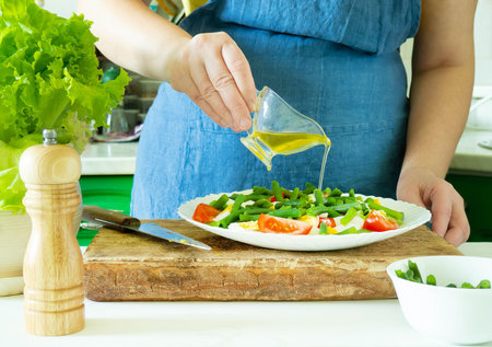 A woman prepares a vegetable salad in the kitchen. Healthy Food. The Concept Of A Diet. Healthy...