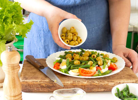 A woman prepares a vegetable salad in the kitchen. Healthy Food. The Concept Of A Diet. Healthy Lifestyle. I Cook At Home. Prepareの写真素材