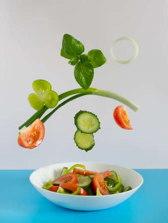 Fresh vegetables fly into the salad. Creative salad.の写真素材