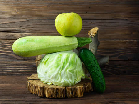 Fresh green vegetables and fruits on a wooden table. Balanced floating balance of food products.の写真素材