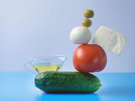 Fresh vegetables fly into the salad on a blue-and-white background. Tomato, cucumber.basil, onion. Creative salad. The concept of healthy food. Balance.の写真素材