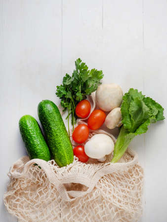 Various vegetables and fruits in an eco bag on a white background, top view. The concept of healthy nutrition, the food basisの写真素材