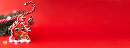Gingerbread house, red clock, gift, lollipop, candy on a red background.の写真素材