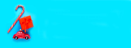 Red car, candy on a blue background. Banner. A place to copy..