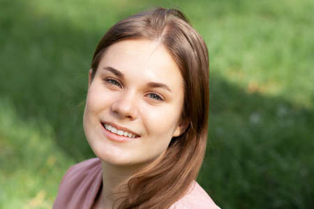 Portrait of a girl in pink on a green lawnの写真素材