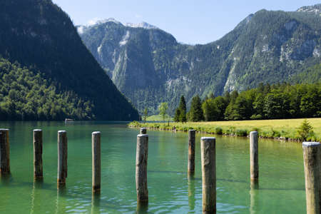 mooring posts on an alpine mountain lake with emerald waterの写真素材