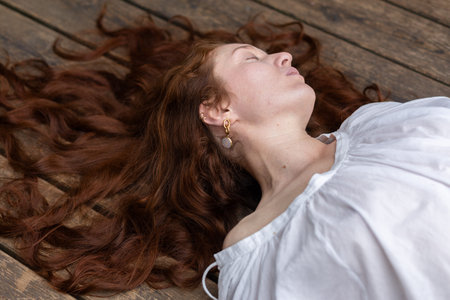 Portrait of a young woman lying on a wooden floor