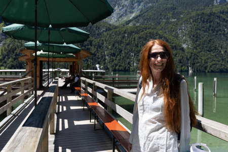 Young woman waiting to board a boat on the lakeの写真素材