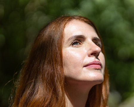 Close-up portrait of a mature light-eyed red-haired beautiful middle-aged womanの写真素材