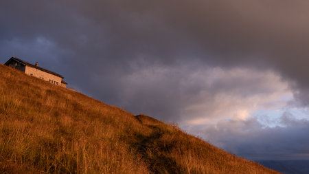 mountain hut on an alpine mountain in evening illuminationの写真素材