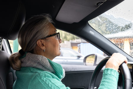 The gray-haired lady drives her own carの写真素材