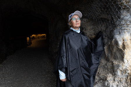 An adult woman stands at the entrance to an illuminated mountain tunnel, Austria, Salzburgの写真素材