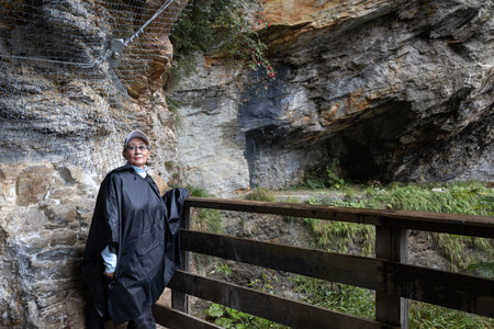 An adult woman stands at a rocky passage in the Alps, Austria, Salzburgの写真素材