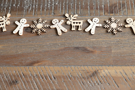 A horizontal pattern of Christmas wooden decorations lies on a beautiful wooden table, space for textの写真素材