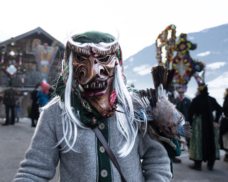 AUSTRIA, GASTEIN - January 1, 2023: Witch with a stuffed bird on her shoulder in the Perchtenlauf processionのeditorial素材