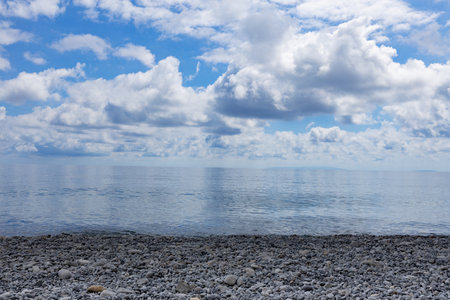 Picturesque seascape with a pebble beach, azure sea and voluminous light clouds in a bright blue sky, Greece, Creteの写真素材