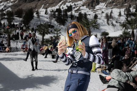 AUSTRIA, SPORTGASTEIN - March 18, 2023: Event Palmen auf den Almen, girl filming what is happening on the phoneのeditorial素材