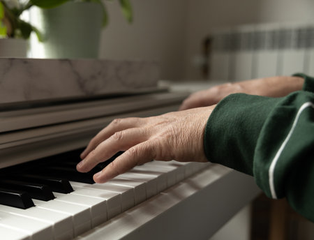 Mens hands play a piece of music on a home pianoの写真素材