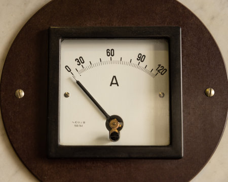 An antique non-working ammeter in a wooden frame hangs on the wallの写真素材