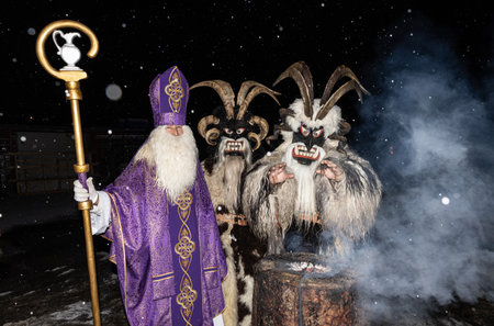 Christmas heroes, St. Nicholas and krampus basking in a smoking stump, Austria, Gasteinの写真素材