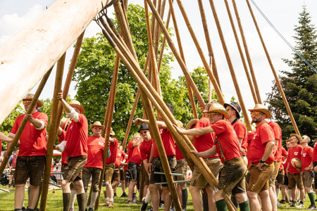 AUSTRIA, SALZBURG - 7 MAI, 2023: young men in national shorts and hats plant a maypole in the grounds of Stieglのeditorial素材