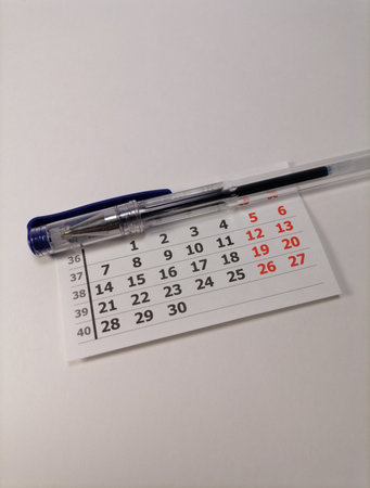 Calendar with a pen lie on a white surface